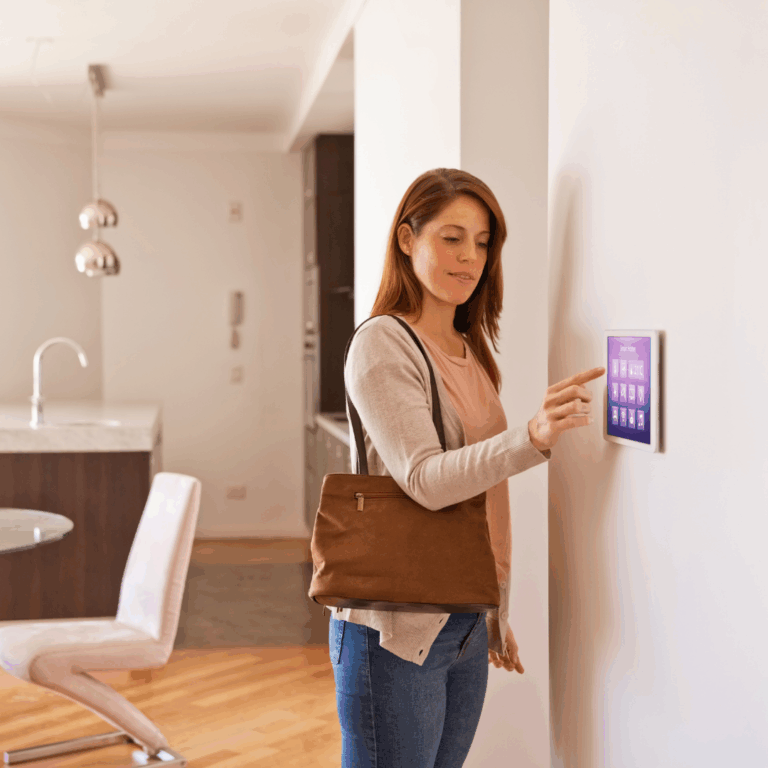 Eine Frau steht in ihrem Esszimmer und bedient ein Tablet an der Wand, auf dem ein Smart Home System installiert ist.